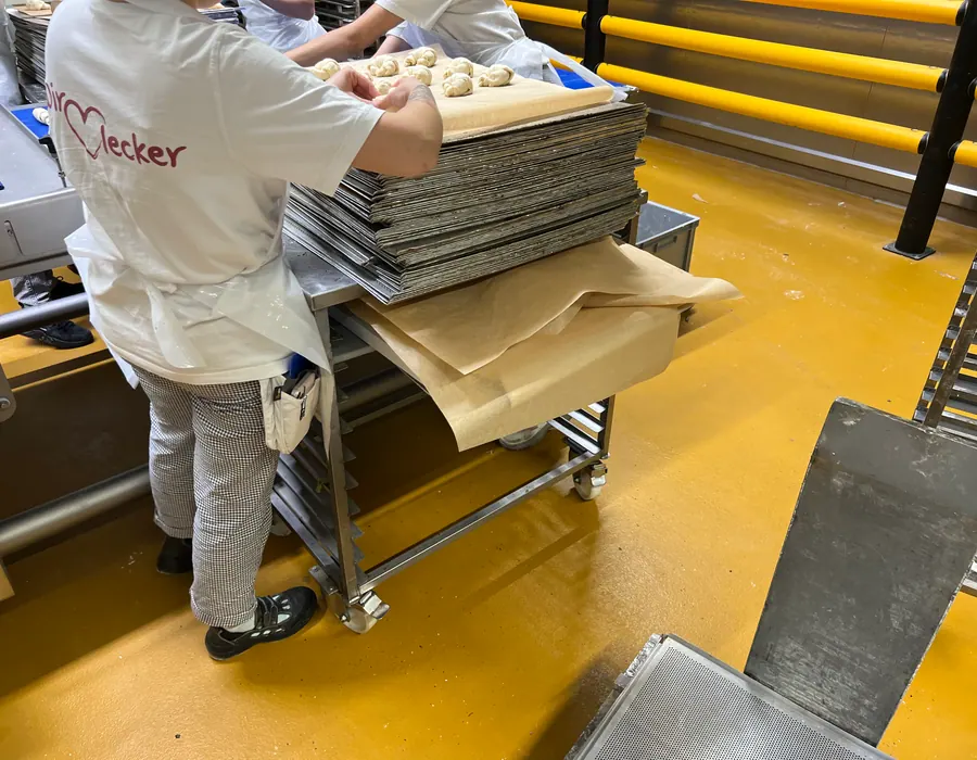 Bäckereimitarbeiter bei der Teigverarbeitung — Hygiene und HACCP im Alltag.