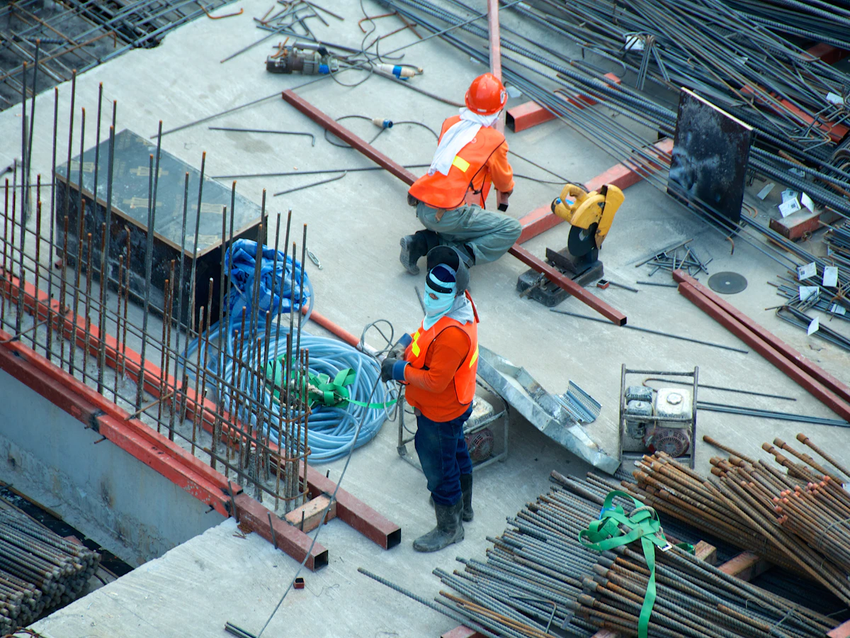 Bauarbeiter bei Bewehrungsarbeiten auf der Baustelle — Mängelerfassung und Dokumentation vor Ort.